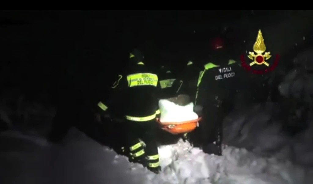 pmpieri nella notte portano in salvo un sopravvissuto della valanga